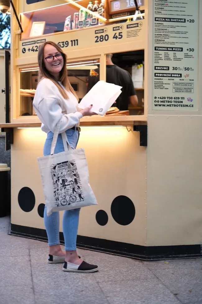 Zákaznice s pizzou a taškou Metro u okna