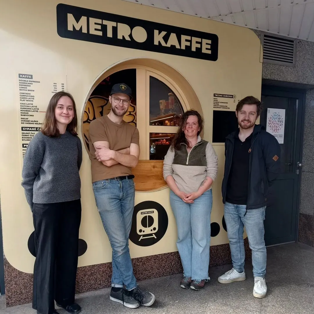 Tým Metro Kaffe opřený o budku v podchodu